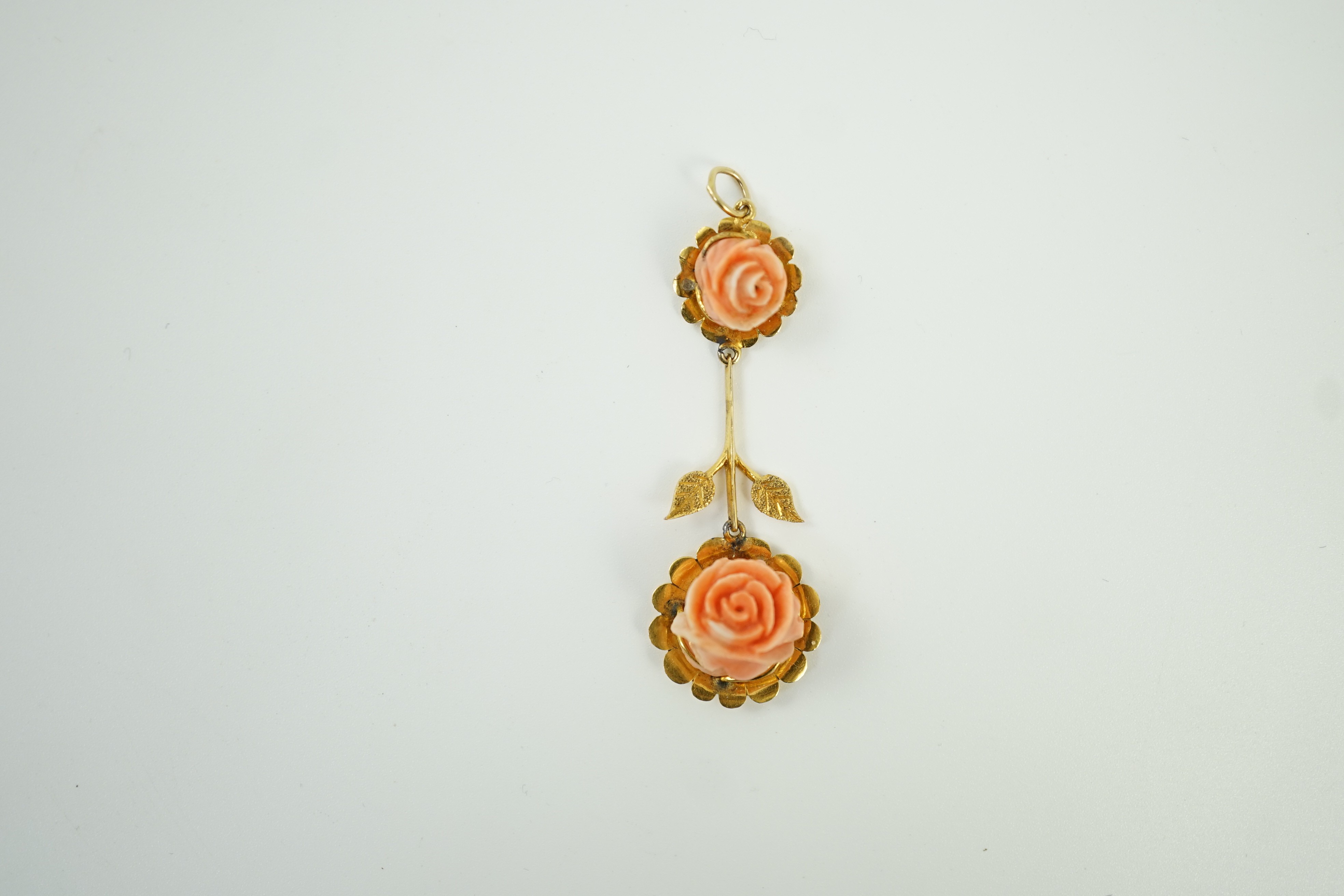 A yellow metal and two stone carved coral set 'rose' drop pendant, overall 57mm, gross weight 6 grams.